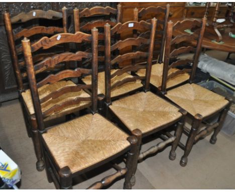 A set of 6 oak ladder back dining chairs with rush seats and pad feet.
