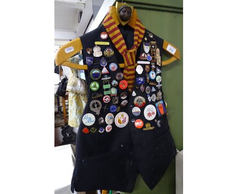 A waistcoat displayed with a collection of enamelled and other Vintage badges.