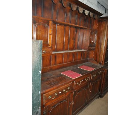 A good reproduction oak dresser, the top having shelves, cupboards and drawers, the base fitted with 3 frieze drawers and fie