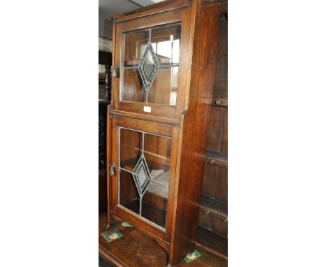 An Art Deco oak bookcase, having coloured lead light glazed panels, of narrow size, width 44cm, height 120cm.