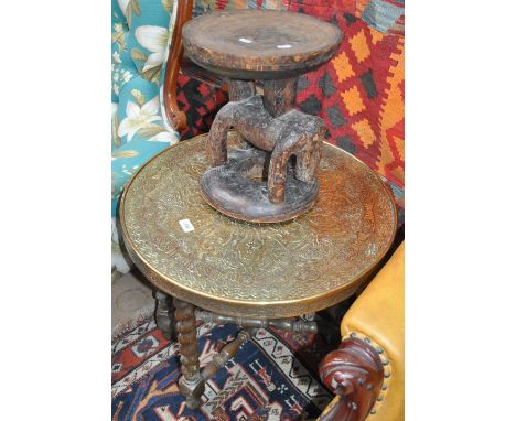 An embossed brass top table on folding base and a carved African stool with animal base