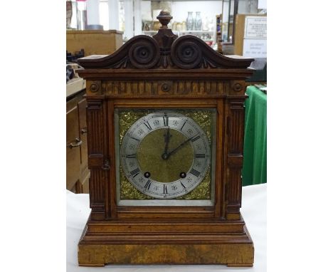 A mantel clock with 2-train movement in carved mahogany case.