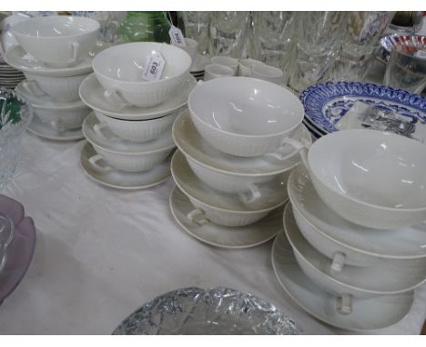 Set of 12 Royal Copenhagen white porcelain soup bowls and saucers with embossed decoration.