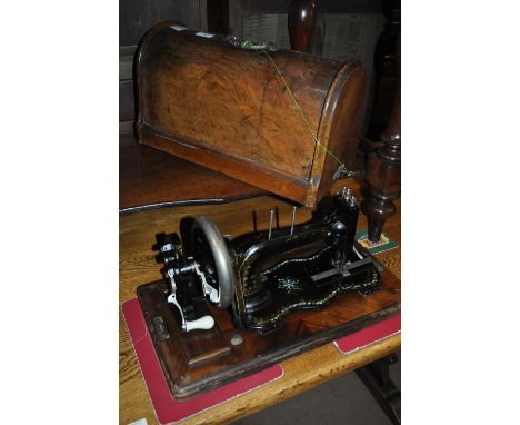 A Vintage walnut cased sewing machine with gilded and mother of pearl decoration.