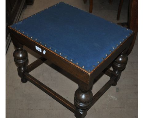 A 1920s oak stool with baluster legs, width 50cm.