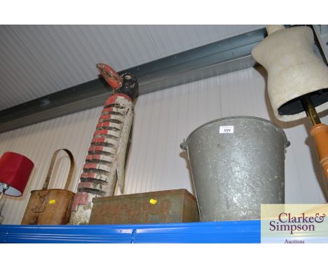 A galvanised bucket; a cast iron planter; a carved wooden penguin and a bottle carrier