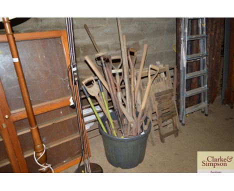 A plastic planter and contents of various long handled gardening tools