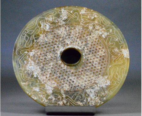 A Chinese jade bi-disc, the outer border with geometric incised decoration and with raised 'stud' decoration to the inner por