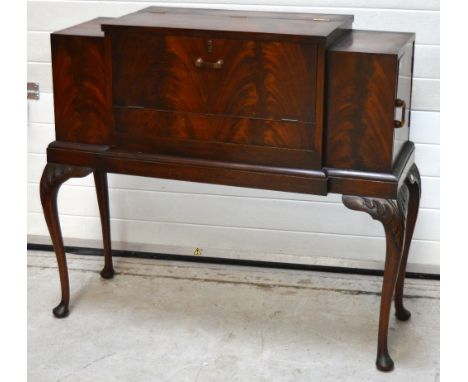 A 20th century flame mahogany cocktail cabinet with integral accessories for making cocktails to include a pair of crystal de