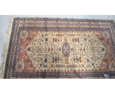 A vintage Pakistani cream and terracotta ground rug with geometric border and a symbolic design to the centre, 188 x 118cm.