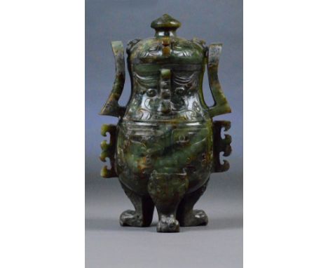 A Chinese russet included carved jade twin handled vase and cover of archaic form with high scrolling loop handles, three paw