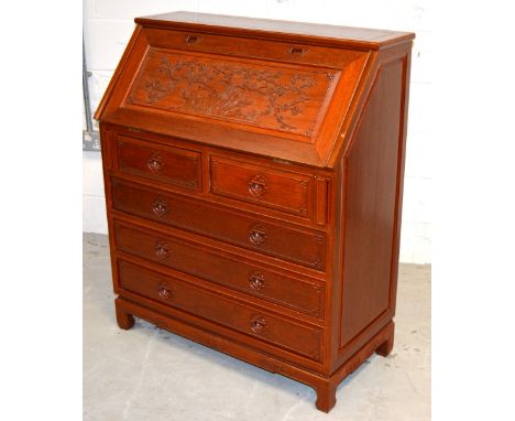 A 20th century Oriental hardwood bureau with fall front desk top carved with an Oriental scene of cherry blossom and birds ab
