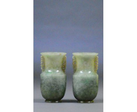 A pair of Chinese jade baluster vases with pierced scrolling handles and plain mottled green bodies, height 10cm (2).