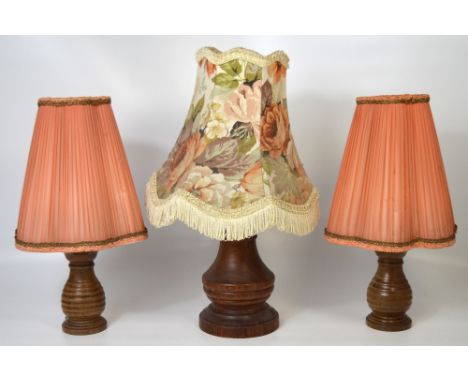 Three wood table lamps to include a retro baluster table lamp with full shade and a pair of turned wood lamps with peach chif