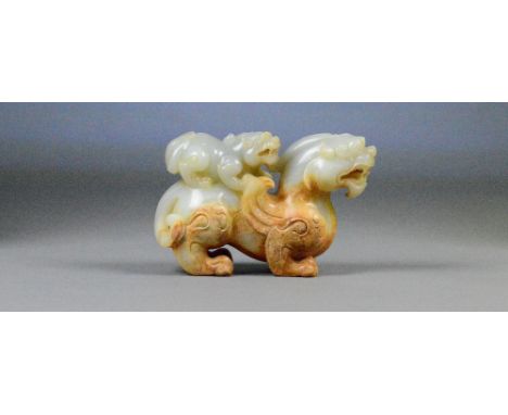 A Chinese pale celadon and russet included carved jade model of a dragon with small dragon upon the back, length 15cm.