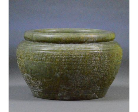 A large Chinese jade bowl with archaic incised decoration throughout and folded rim, diameter 19cm.