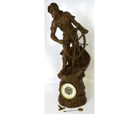 A large spelter clock modelled as a fisherman holding a wheel, enamel dial set with Arabic numerals, height 68cm.