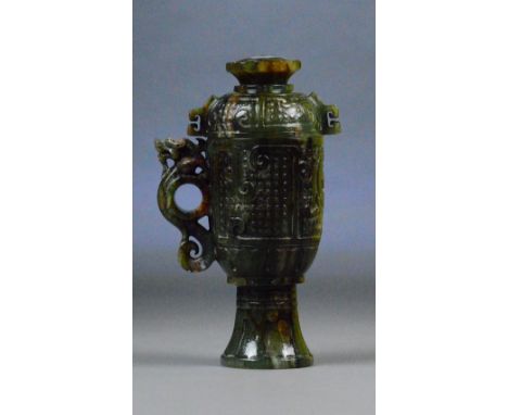 A Chinese dark jade and russet included cup and cover with pierced scrolling stylised dragon handle and incised archaic style