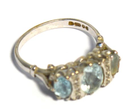 A lady's 18ct white gold dress ring with three pale blue graduating tourmaline stones and interspersed by two bands of tiny d