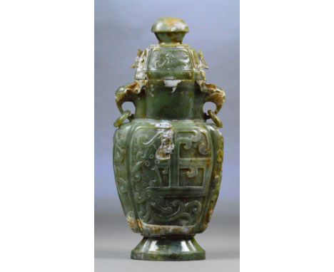 A large Chinese jade and russet included twin handled vase and cover with elephant mask drop ring handles and archaic design 