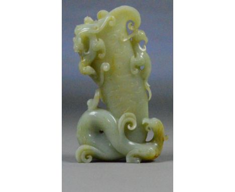 A Chinese pale celadon and slight russet included carved jade vase moulded as a dragon with further small applied dragons and