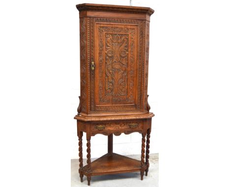 A 19th century carved oak corner unit comprising a wall hanging cupboard, height 103cm, carved frieze over a central door car