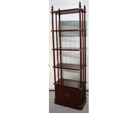 A Pakistani hardwood free standing open display unit, four shelves with brass decoration to each corner each shelf on turned 