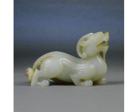 A Chinese mutton fat jade and russet included carved figure of a stylised dragon, length 16.5cm.