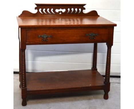 A c.1900 century oak hall table with carved frieze to the back, long drawer over a lower shelf on tapering ribbon supports an