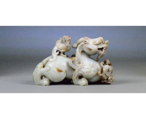 A Chinese pale green and included carved jade figure of a dragon with a phoenix upon its back with small dragon to its front,