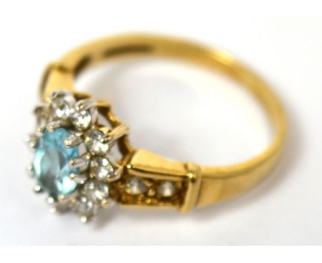 A 9ct gold floral set ring with central blue topaz and white stones, size J, approx 2g.