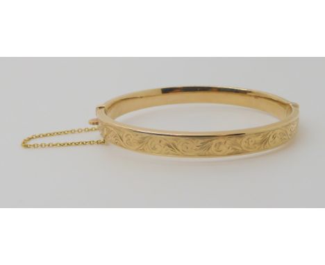 A 9ct gold hollow engraved bangle, inner diameter 6cm, weight 10.3gms Condition Report: Good condition. 
