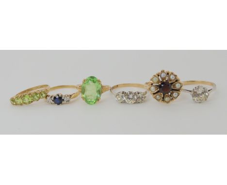 A 9ct gold peridot scroll mount ring size N1/2, a 9ct gold garnet and pearl ring size R1/2, 9ct gold green glass ring size O,