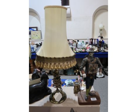 A painted spelter model of a man with clock attached to his front and a faux clock to his back, together with a brass lamp Co