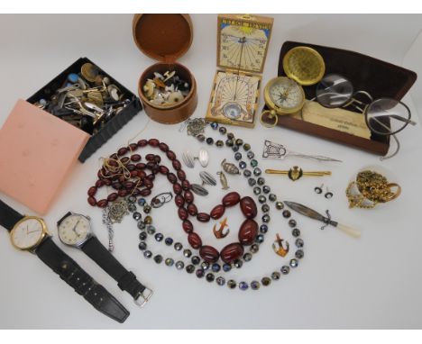 A string of cherry amber coloured beads, collection of vintage gold plated chains, a pocket sundial/compass, and other items 