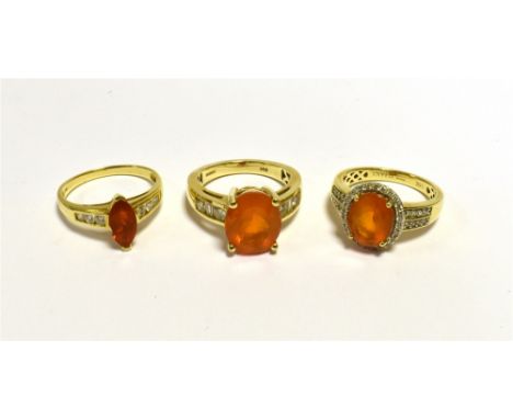 FIRE OPAL &amp; DIAMOND DRESS RINGS  One oval 12.3 x 10mm oval fire opal, flanked by round brillant and tapered baguette cut 