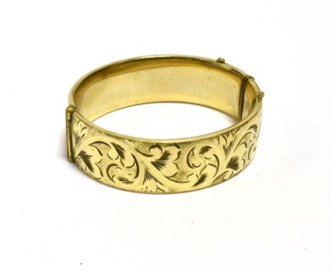 9CT GOLD METAL CORE BANGLE  18.7mm wide with foliate and scroll engraving to front, stamped '1/5th 9ct Metal Core', with orig