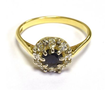 18CT SAPPHIRE &amp; DIAMOND HALO RING  Dark blue round cut sapphire, surrounded by a halo of grain set, single cut diamonds o