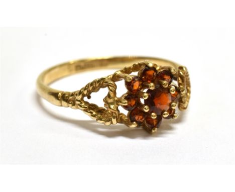 A VINTAGE 9CT GOLD AND ALMANDINE GARNET CLUSTER RING the nine small round stones claw set between rope-twist open heart shoul