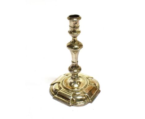 A GEORGE II CAST SILVER TAPER STICK with a spool-shaped capital, a knopped and facetted stem on a slightly-domed shaped-squar