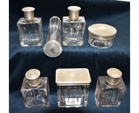 A GROUP OF SEVEN EARLY 20TH CENTURY FRENCH SILVER AND TURQUOISE-ENAMELLED SILVER TOPPED CLEAR GLASS DRESSING TABLE/CASE BOTTL