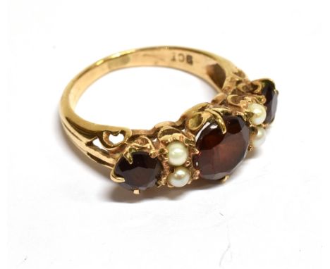 A MID-20TH CENTURY GOLD, GARNET &amp; HALF-PEARL DRESS RING the three graduated round mixed-cut garnets spaced by pairs of pe