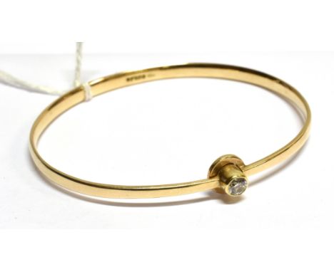 A VINTAGE 9CT GOLD AND DIAMOND SINGLE STONE BANGLE The round brilliant approx. 0.24cts, rub-over set to a sprung bangle with 