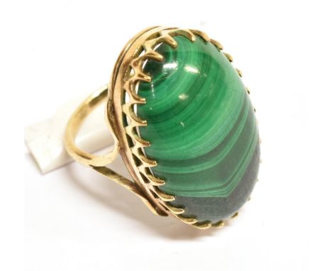 A VINTAGE MALACHITE SINGLE STONE RING the oval cabochon malachite approx. 25mm x 15.5mm, claw set between open split shoulder