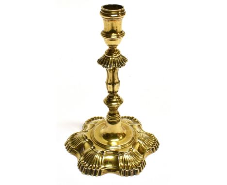 A LATE GEORGE II CAST SILVER-GILT TAPER STICK with a spool-shaped capital, a knopped and fluted baluster stem on a petal-shap