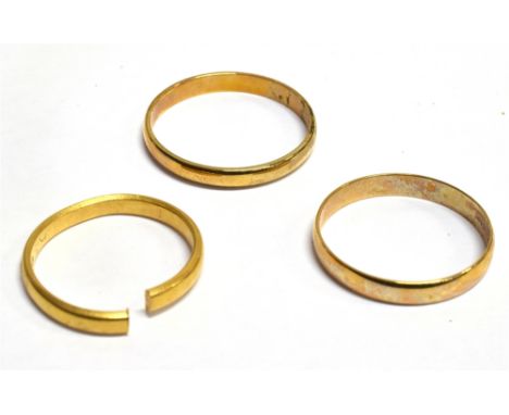 THREE GOLD WEDDING BANDS Comprising; a 22ct gold 'D' section band (sawn-through, Birmingham 1924, 3g; and two modern 9ct gold