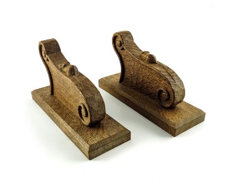 Robert Mouseman Thompson of Kilburn, a pair of Arts and Crafts carved oak wall lights, scroll bracket form, 23cm long (2)