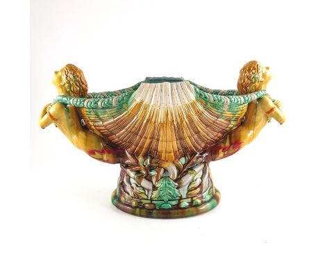 A large majolica centrepiece, after a Minton design, modelled as a scallop shell flanked by two sea nymphs with garland ropes