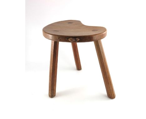 Robert Mouseman Thompson of Kilburn, an Arts and Crafts oak cow stool, the kidney shaped seat supported on three octagonal se