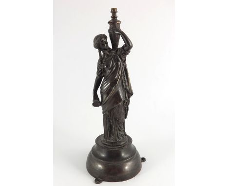 A bronze metal figurative table lamp base modeled as a classical female water carrier figure, circa 1900, dressed in Grecian 